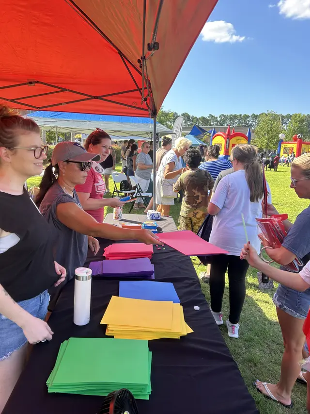 Volunteers organizing supplies at an outdoor community event table